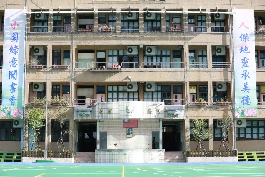 一群小學生揹著書包走向校園，象徵開學情境