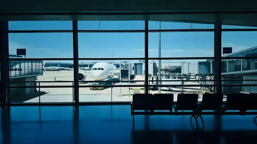機場候機室窗外停靠一架客機，呈現出國搭機情境