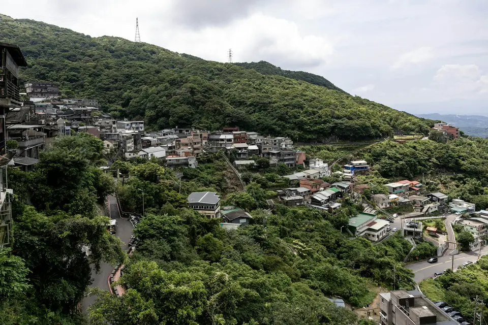 豪雨中的台灣山區道路與聚落，象徵不同日期的停班停課公告需要分開核對