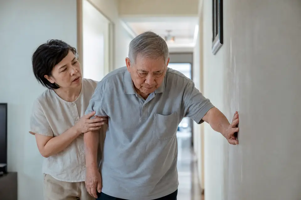 長輩在家中扶著牆、步態不穩的日常畫面