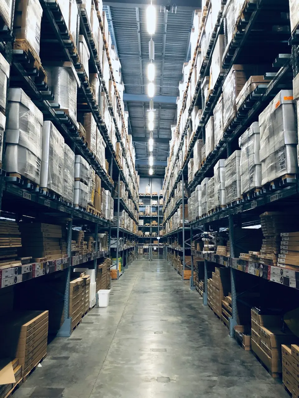 工廠料架上整齊堆放的金屬板件，象徵人形機器人負責取放鈑金件的單一任務
