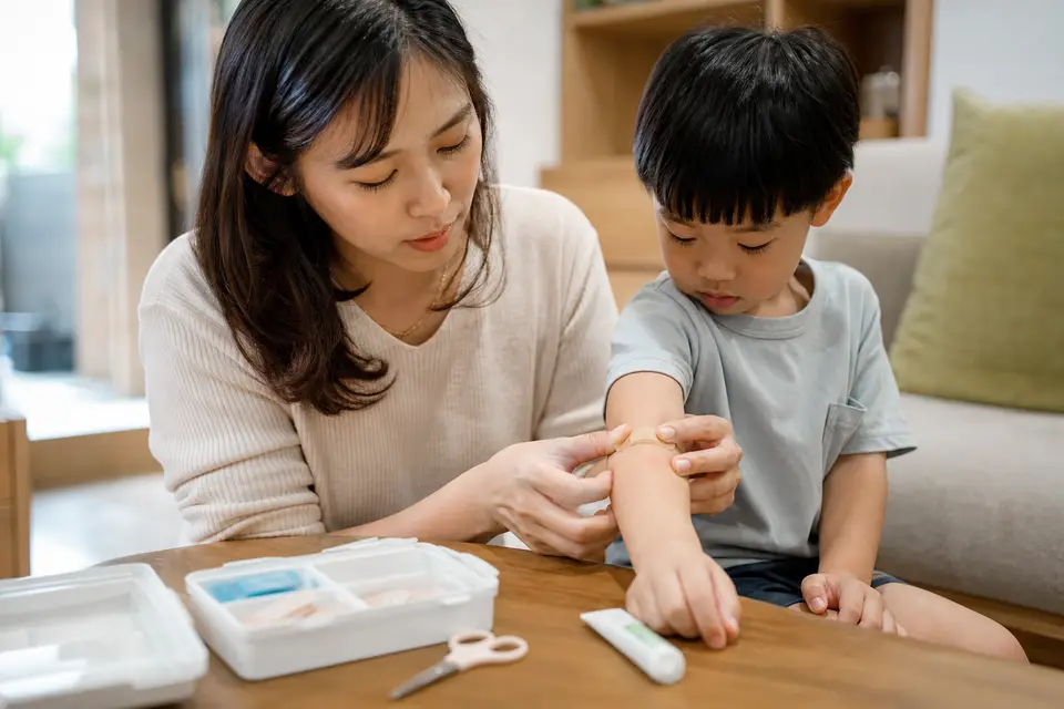 家長替小孩手臂上的蚊蟲叮咬處貼上OK繃