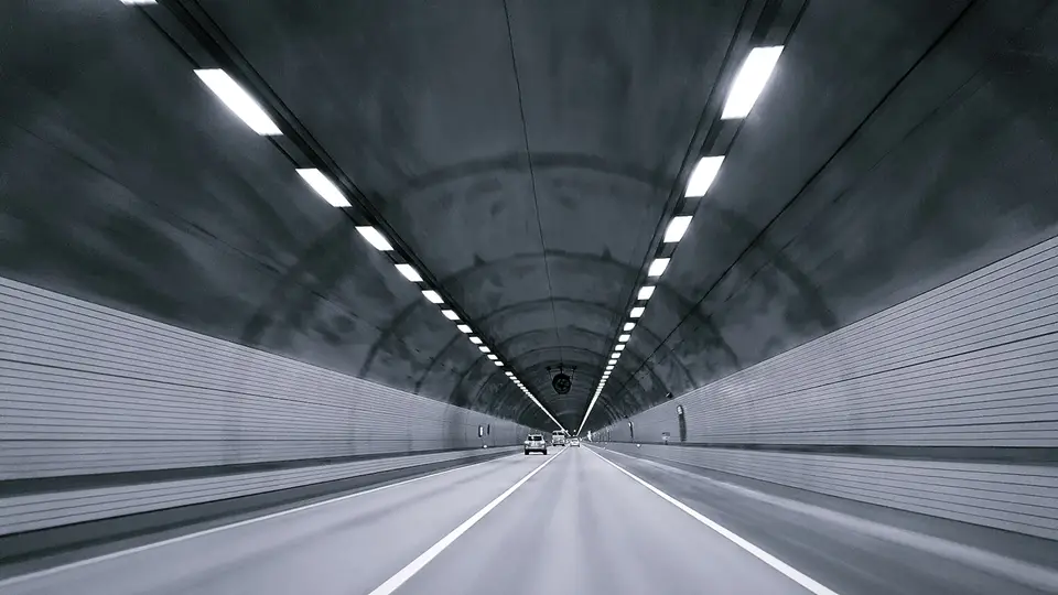汽車行駛於明亮的公路隧道內，隧道燈光沿路延伸（示意圖）