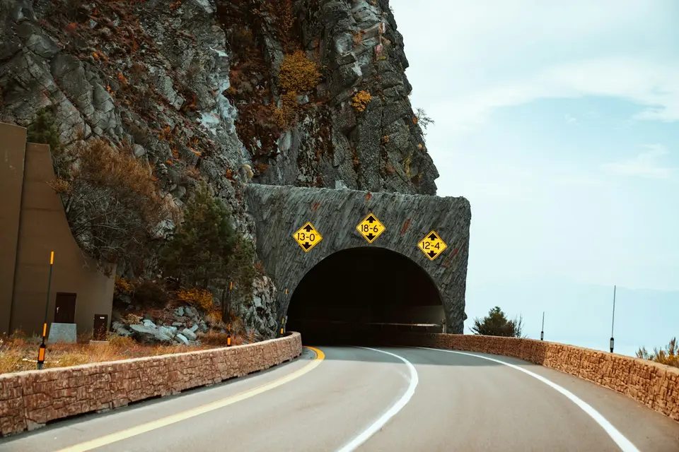 公路隧道洞口，一側是陡峭山壁（示意圖）