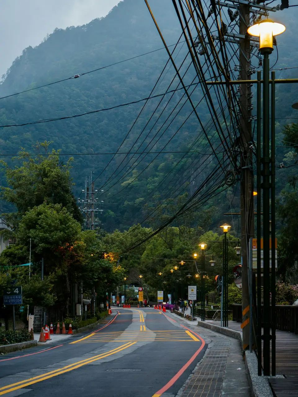 山區道路豎立交通錐與電線杆，象徵警戒區道路管制